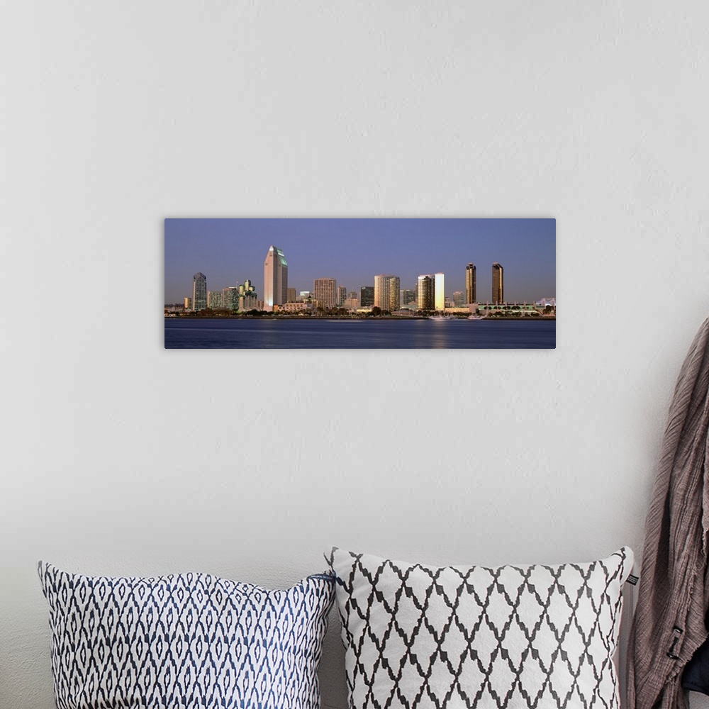A bohemian room featuring Wide angle photograph of the San Diego skyline over the water, beneath a blue sky during the day.