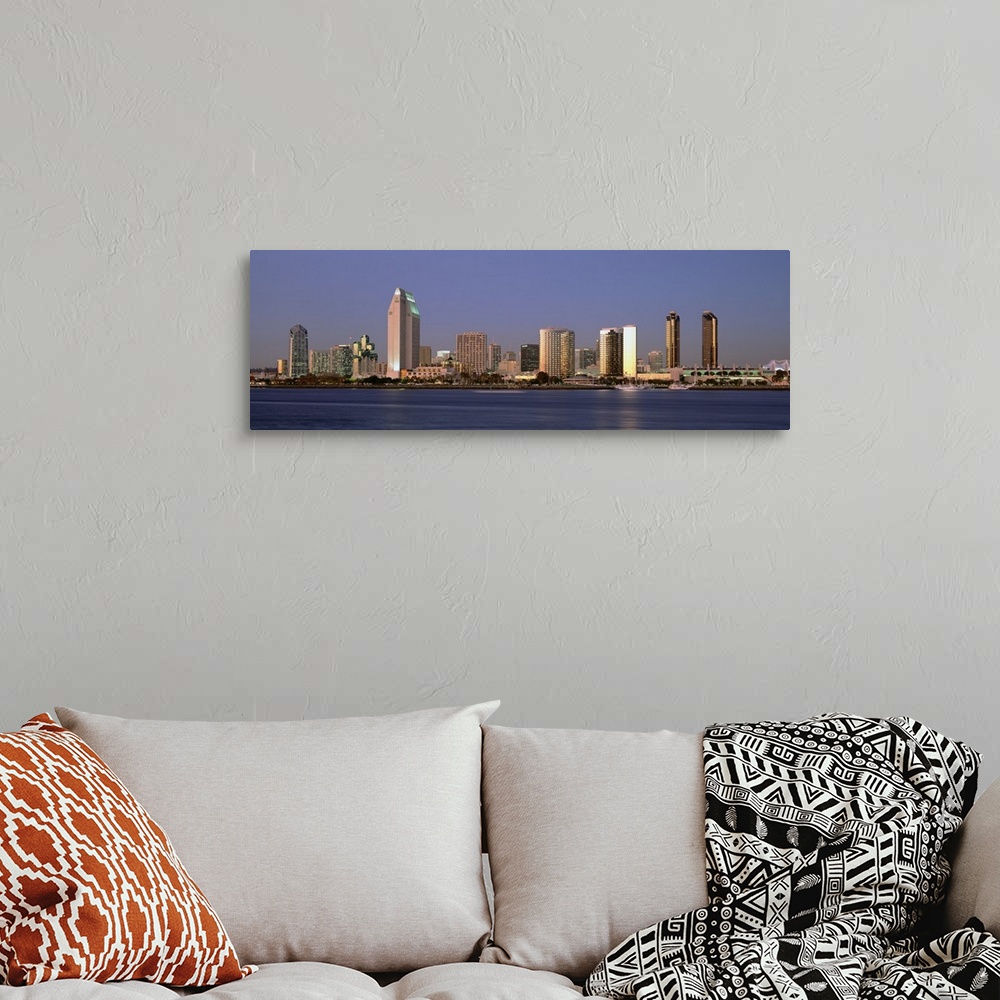 A bohemian room featuring Wide angle photograph of the San Diego skyline over the water, beneath a blue sky during the day.