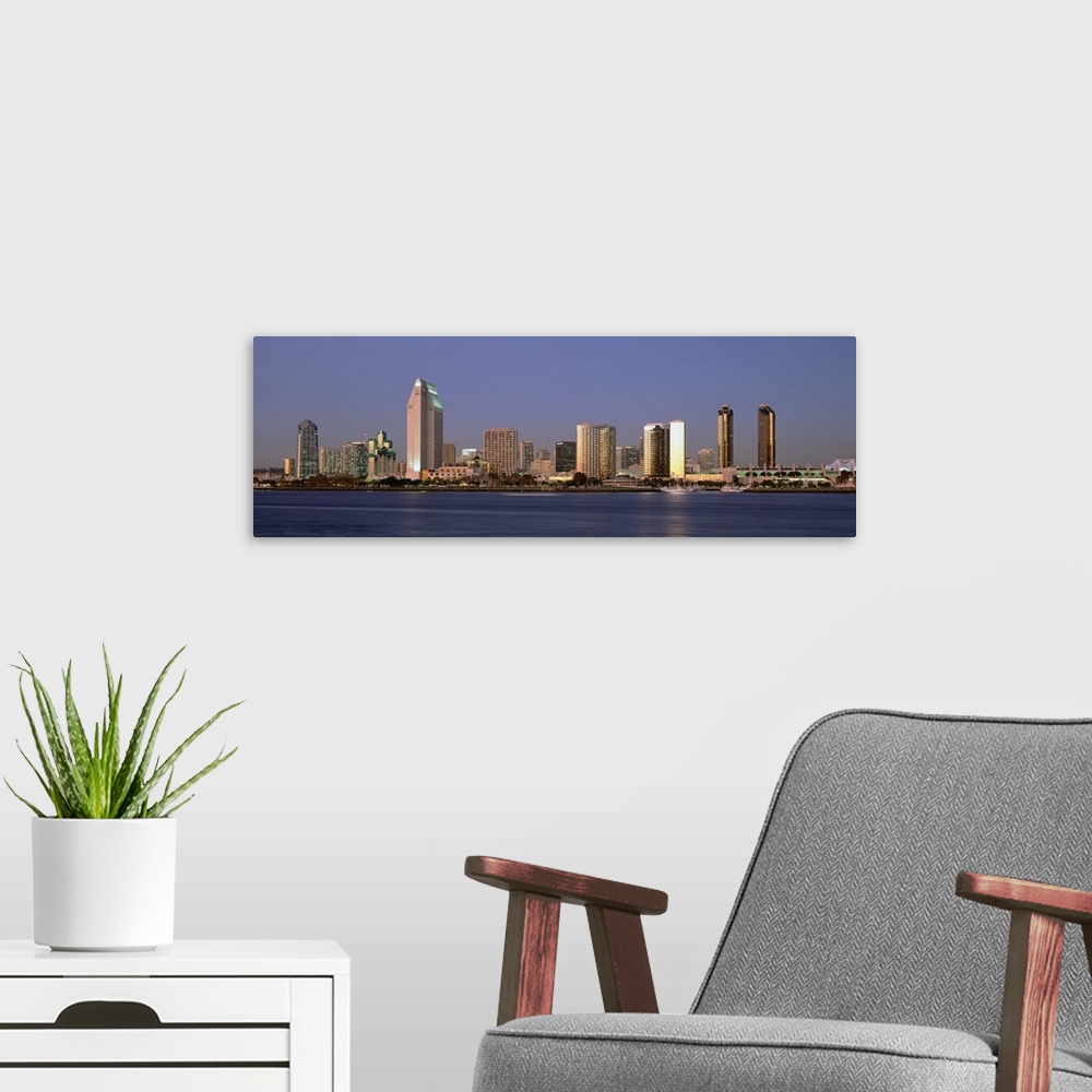 A modern room featuring Wide angle photograph of the San Diego skyline over the water, beneath a blue sky during the day.