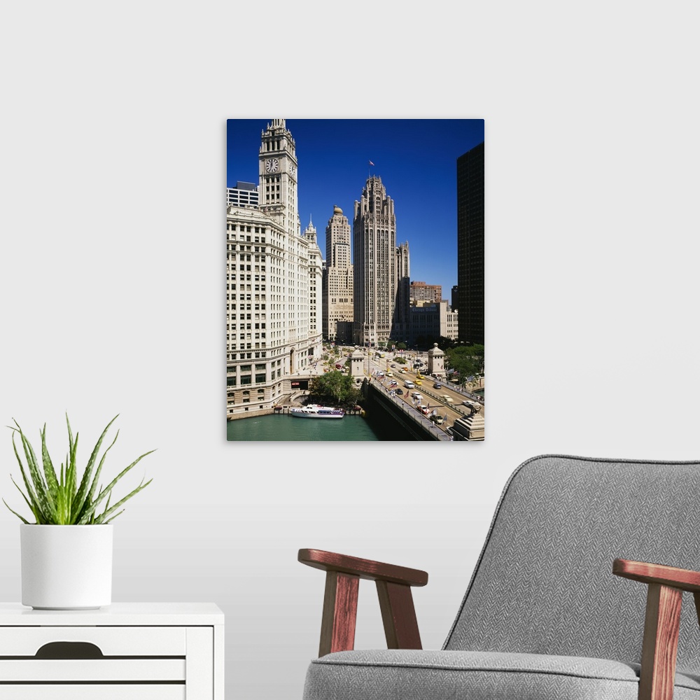A modern room featuring Tall skyscraper buildings in downtown Chicago along the river as cars hustle about the busy streets.