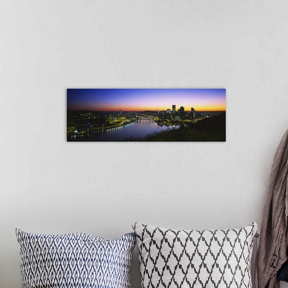 A bohemian room featuring Panoramic photograph of skyline and waterway at sunrise.