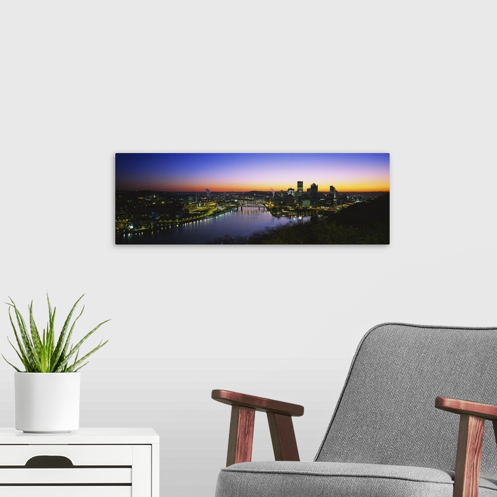 A modern room featuring Panoramic photograph of skyline and waterway at sunrise.