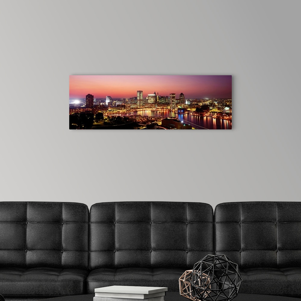A modern room featuring High angle photograph of the Baltimore Inner harbor at night reflecting in the water.