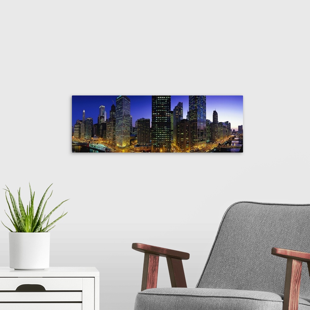 A modern room featuring Panoramic photograph of skyline with buildings and streets glowing in night sky.