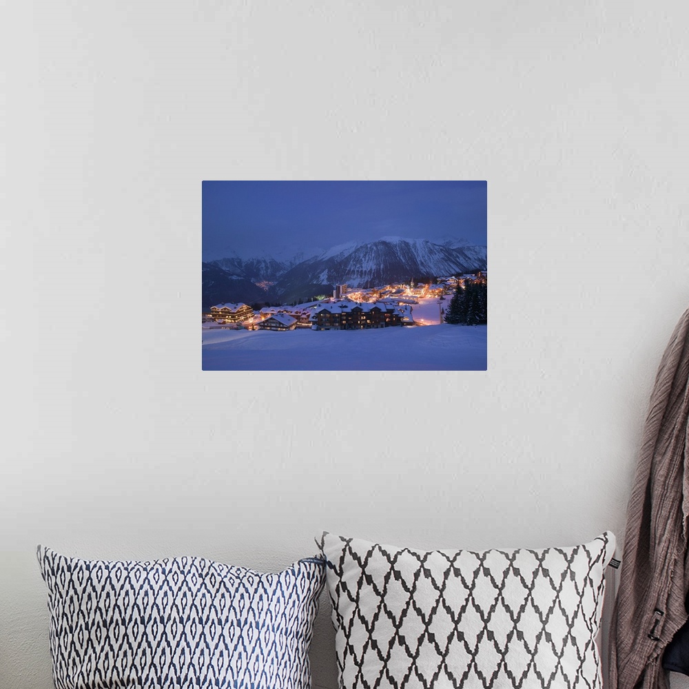 A bohemian room featuring Photograph of small town nestled at the bottom of snow covered mountain at night.