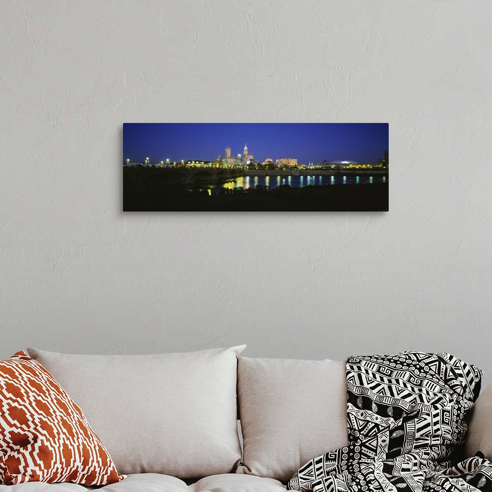 A bohemian room featuring Big panoramic photo on canvas of a lit up city skyline past a bridge over a river.