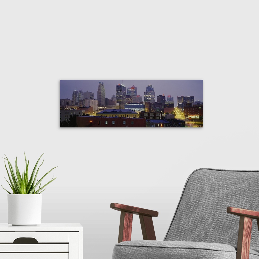 A modern room featuring A panoramic photograph of the downtown city skyline with several small residential or warehouse b...