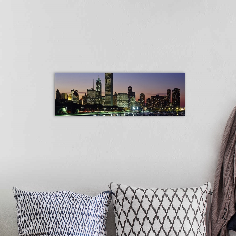 A bohemian room featuring A wide angle picture taken of the Chicago skyline during sun down with the buildings illuminated.