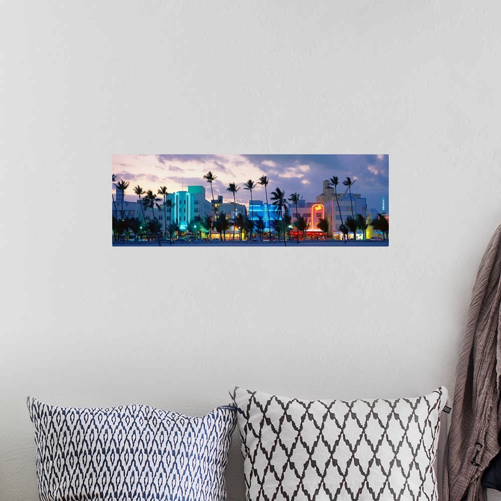 A bohemian room featuring Panoramic photograph includes a row of tall properties vibrantly shining alongside groups of palm...