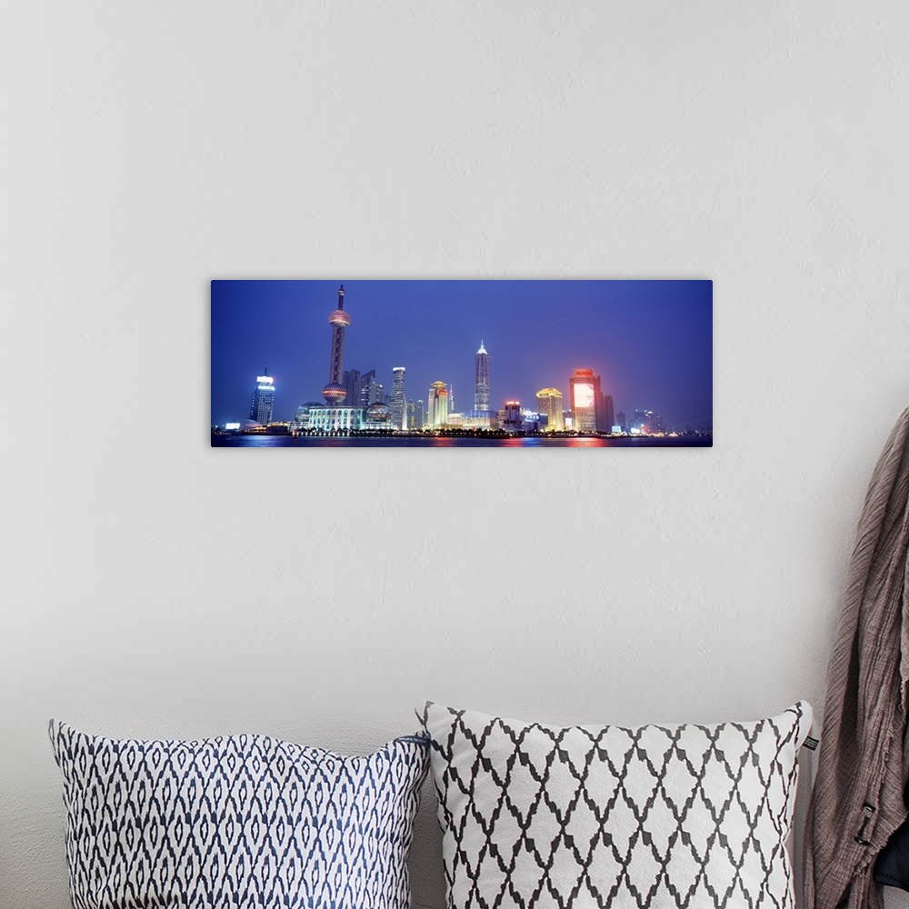 A bohemian room featuring Panoramic photograph of skyline and water front at night.