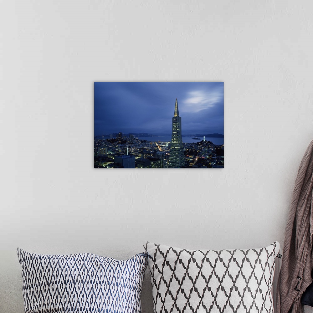 A bohemian room featuring Photograph of skyline under dark cloudy sky with waterfront in distance.