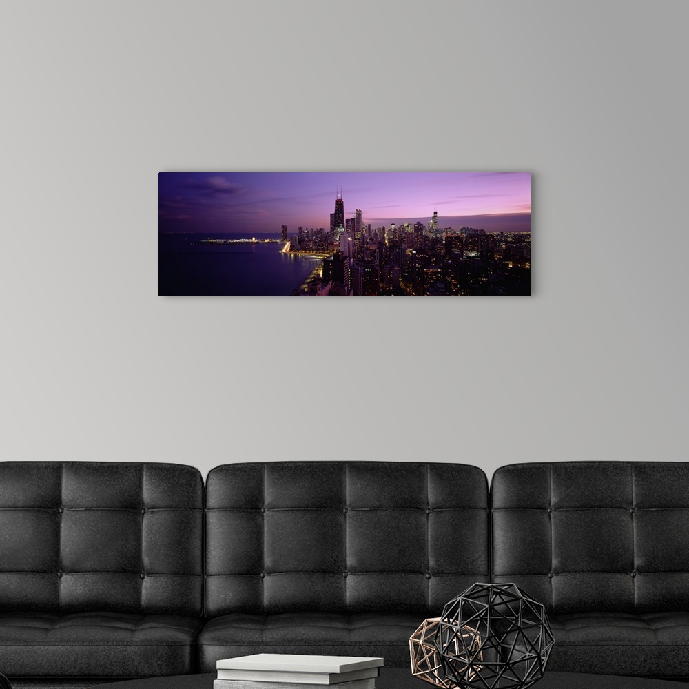 A modern room featuring Narrow and horizontal canvas of downtown Chicago lit up at night with the waterfront on the left.