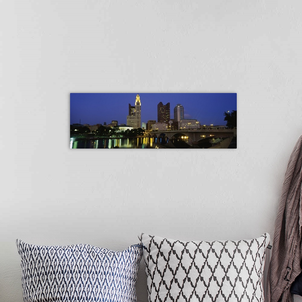 A bohemian room featuring The city of Columbus Ohio is illuminated under a night sky and photographed in panoramic view fro...