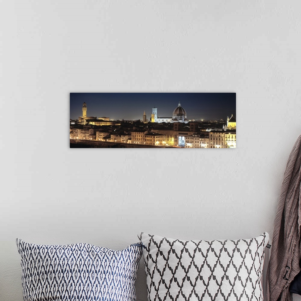 A bohemian room featuring Long and horizontal photo on canvas of the cityscape of Tuscany illuminated at night.