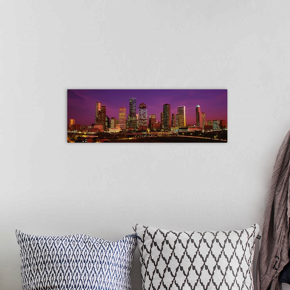 A bohemian room featuring A panoramic photograph of this skyline and surrounding roads at twilight.
