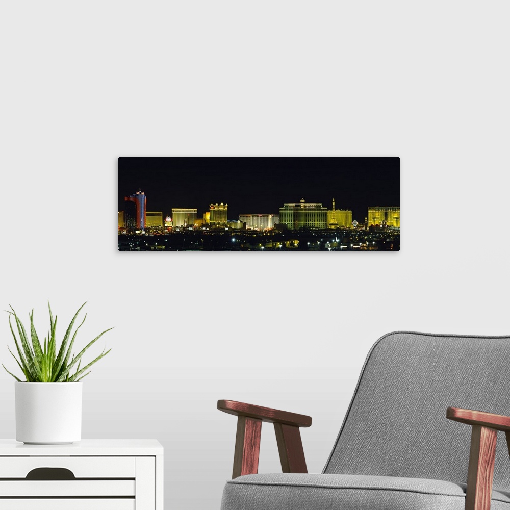 A modern room featuring Landscape photograph on an oversized wall hanging of the brightly lit buildings of the Las Vegas ...