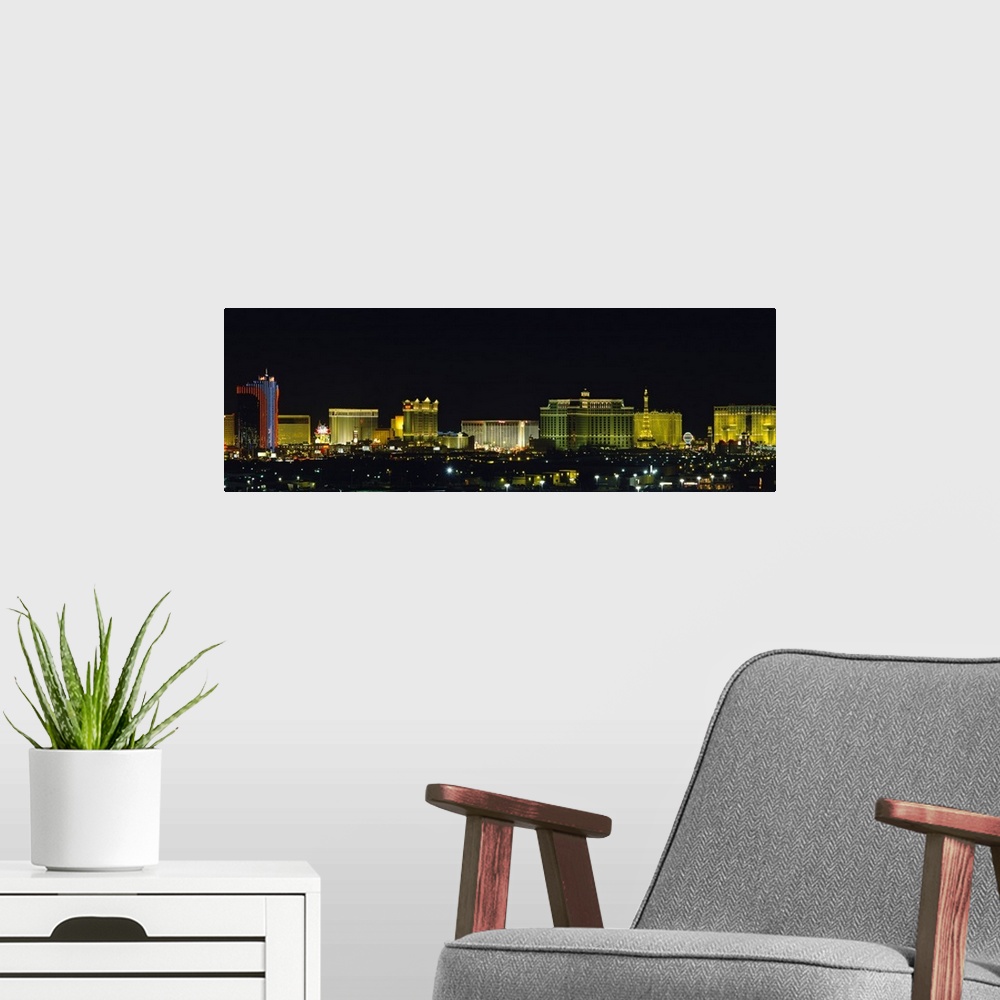 A modern room featuring Landscape photograph on an oversized wall hanging of the brightly lit buildings of the Las Vegas ...