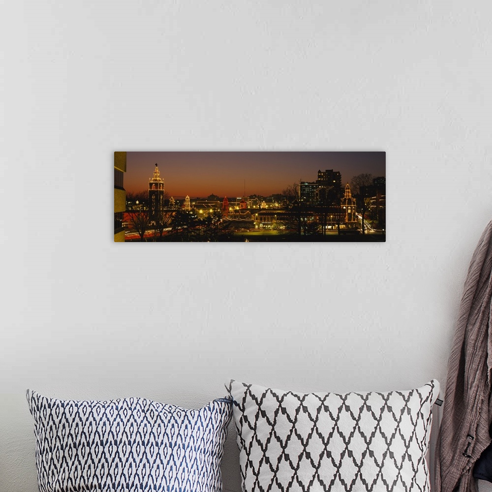 A bohemian room featuring A panoramic picture of a city skyline with lights outlining the buildings and bare trees in the f...