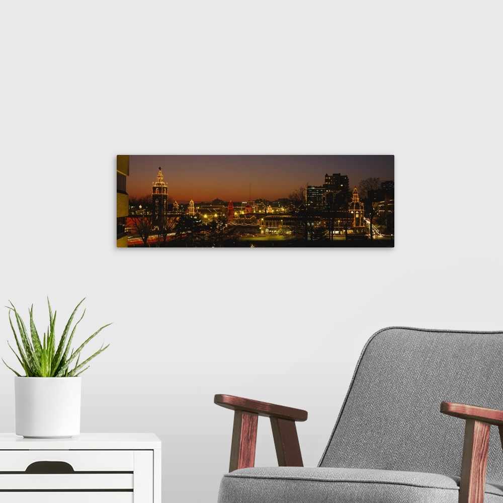 A modern room featuring A panoramic picture of a city skyline with lights outlining the buildings and bare trees in the f...