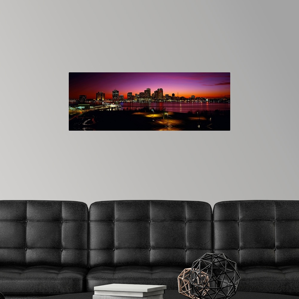 A modern room featuring Panoramic photograph of city skyline at sunset.  The lights from the buildings and street lamps a...