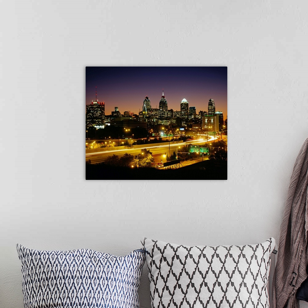 A bohemian room featuring A time lapsed, landscape photograph showing the light trails of high way traffic entering and lea...