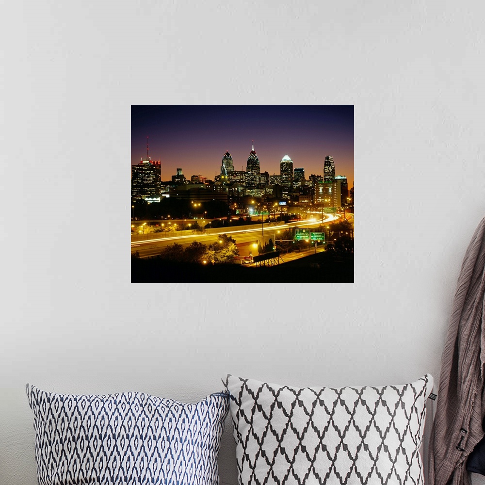 A bohemian room featuring A time lapsed, landscape photograph showing the light trails of high way traffic entering and lea...