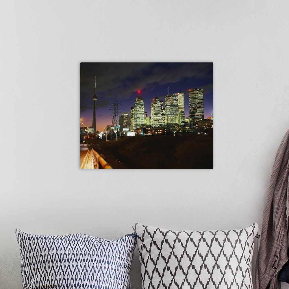 A bohemian room featuring Landscape photograph taken from a street of brightly lit skyscrapers beneath a cloudy sky at nigh...