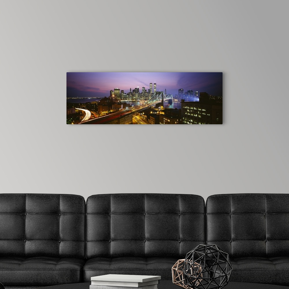 A modern room featuring Panoramic image of lower Manhattan lit up at night with the World Trade Center buildings  and the...