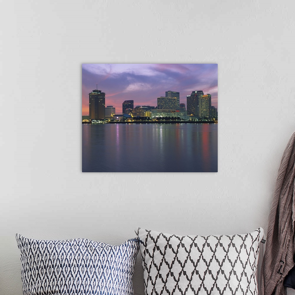 A bohemian room featuring Panoramic photograph of skyline at waterfront.  The building lights are reflected in the water be...