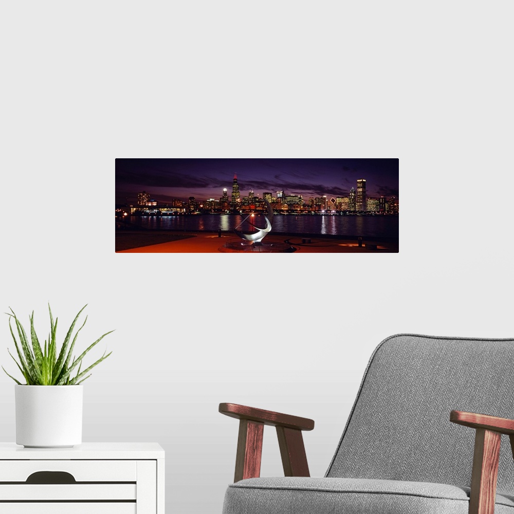 A modern room featuring Panoramic photograph of skyline and waterfront at night.