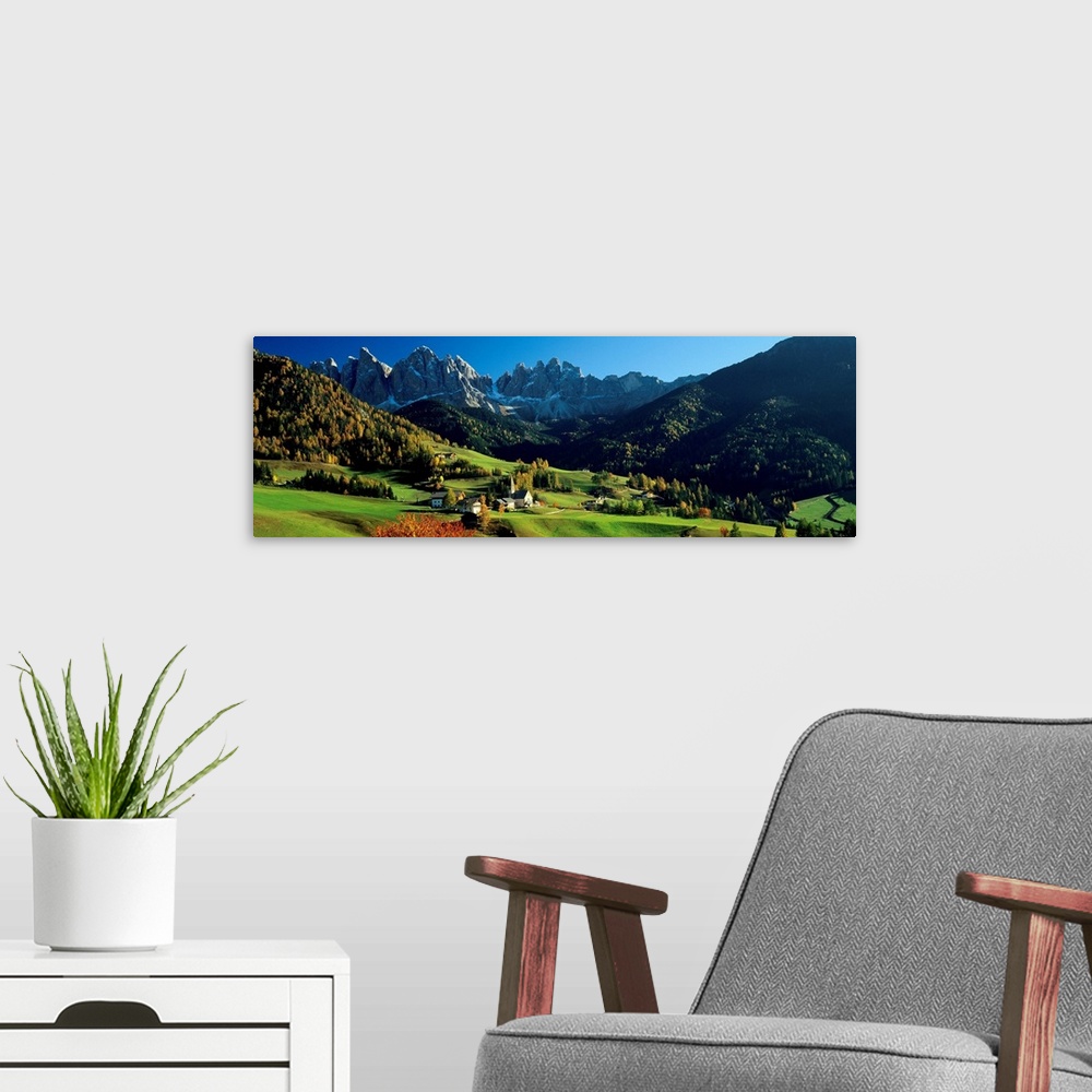 A modern room featuring Panoramic photograph shows an aerial view overlooking an open mountainous region of Europe that i...