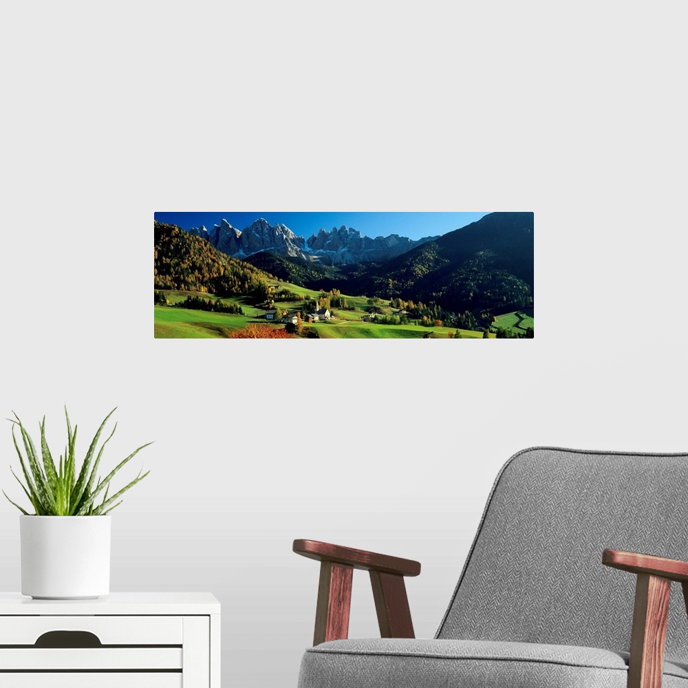 A modern room featuring Panoramic photograph shows an aerial view overlooking an open mountainous region of Europe that i...