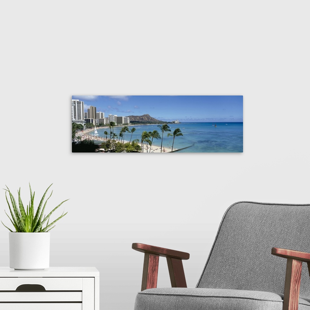 A modern room featuring A panoramic photograph of skyscrapers and beach goers lining the shore of this tropical beach at ...