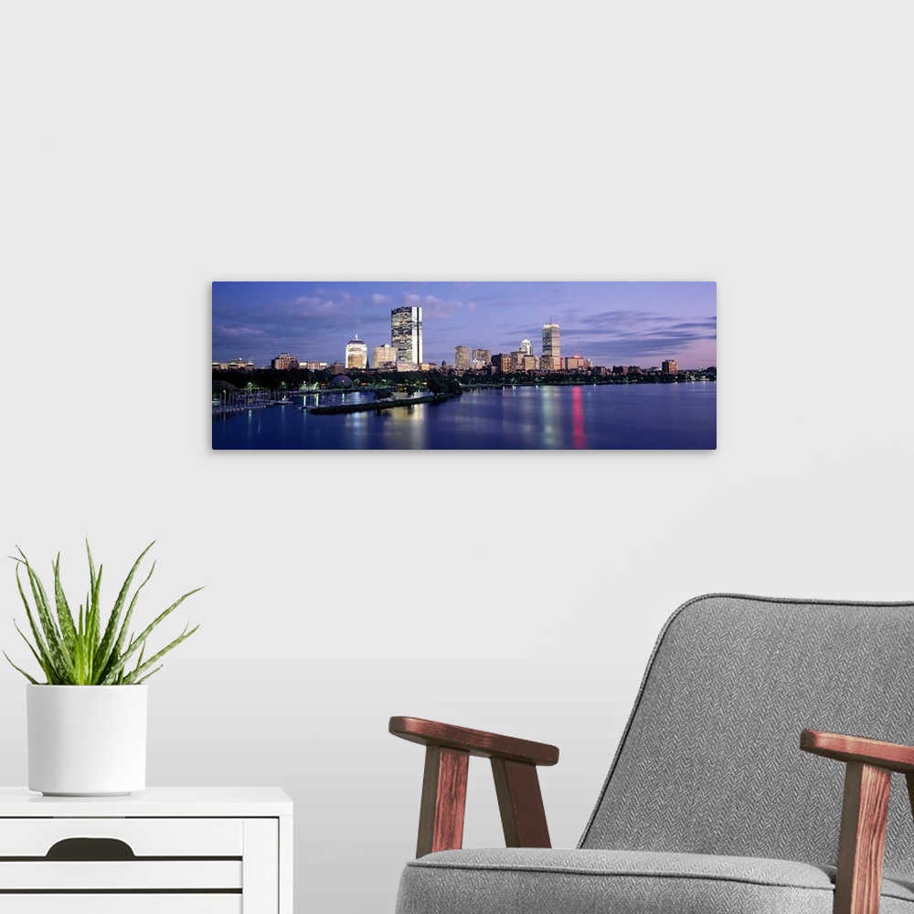 A modern room featuring This panoramic photograph is taken at sun down of the Boston skyline with a body of water shown i...