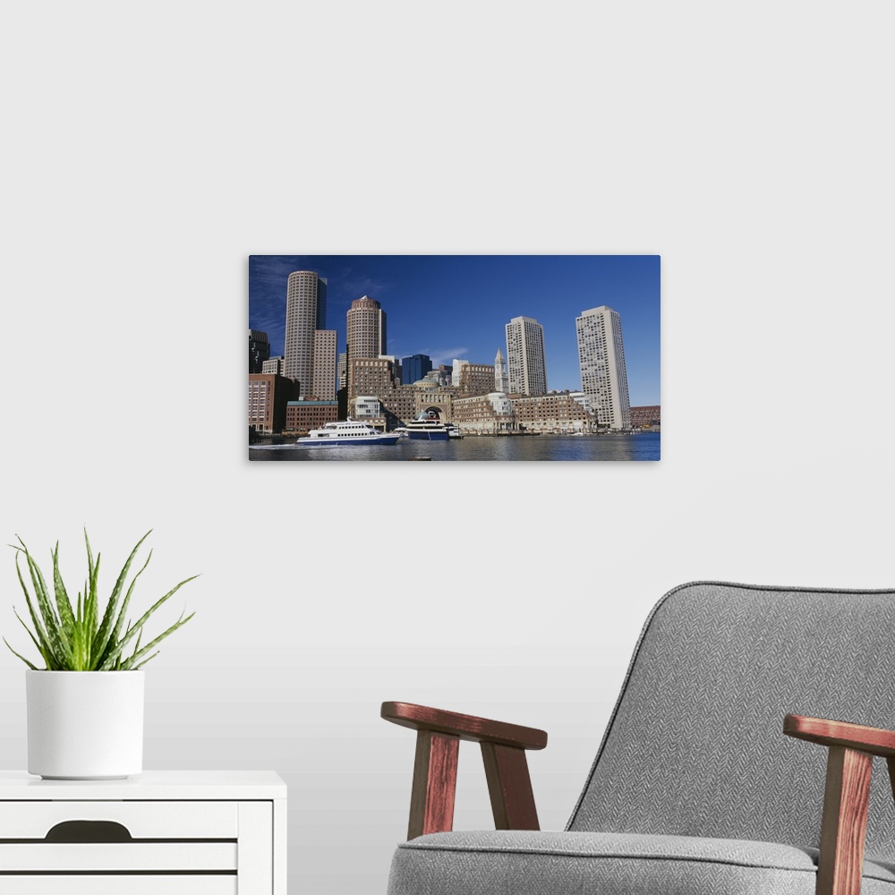 A modern room featuring Wall docor of buildings in Boston on the water with a boat passing by.