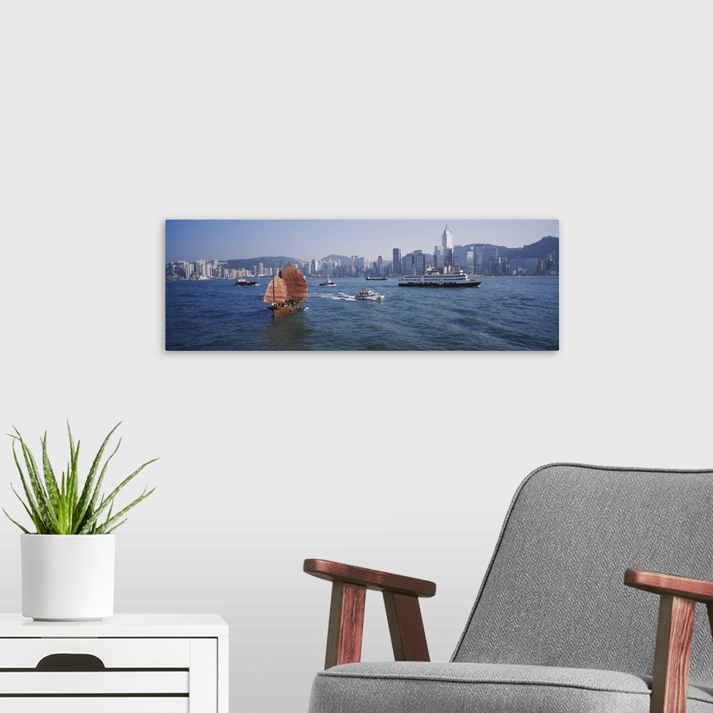 A modern room featuring Panoramic print of ships sailing in the ocean with a downtown cityscape in the distance meeting t...