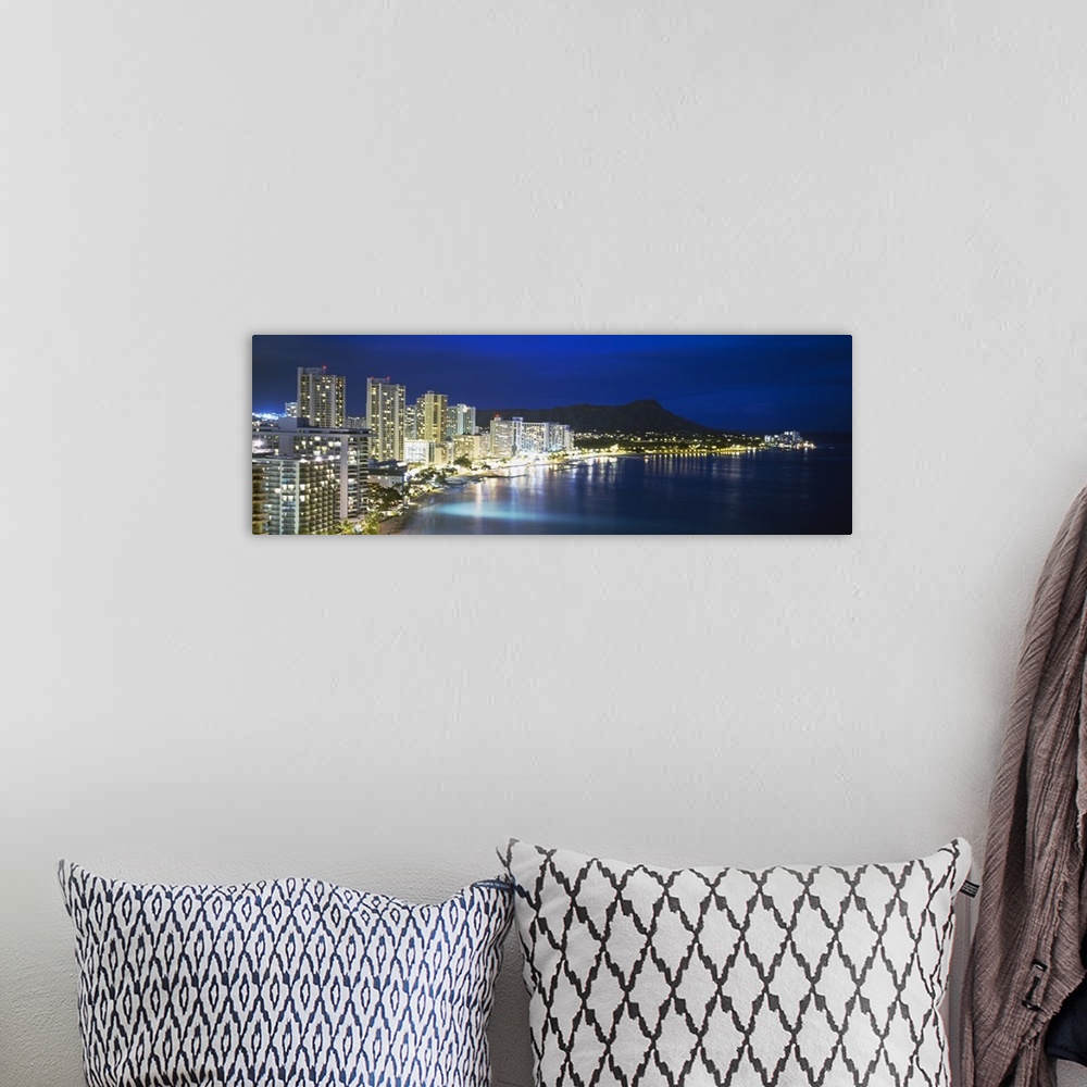 A bohemian room featuring Panoramic photograph shows an illuminated skyline shining brightly on the coast of an island with...