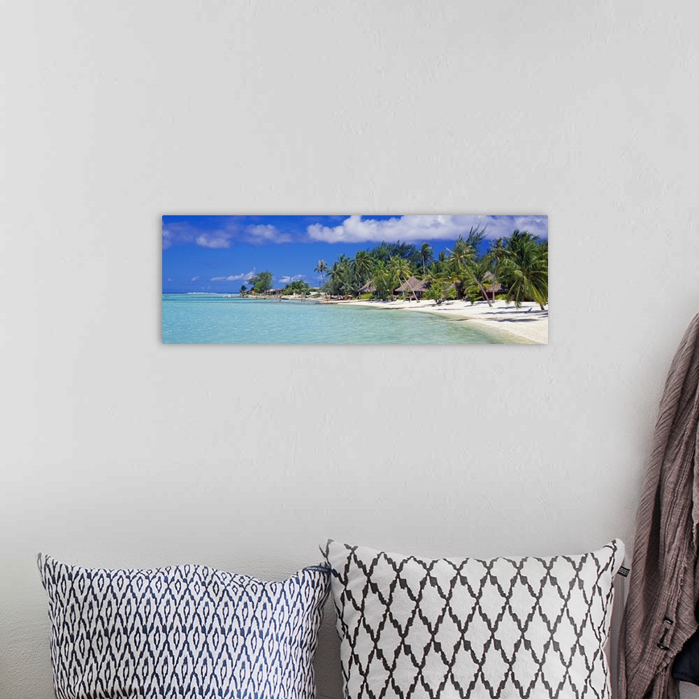 A bohemian room featuring Panoramic photograph on a big canvas of many bungalows nestled amongst palm trees along the coast...