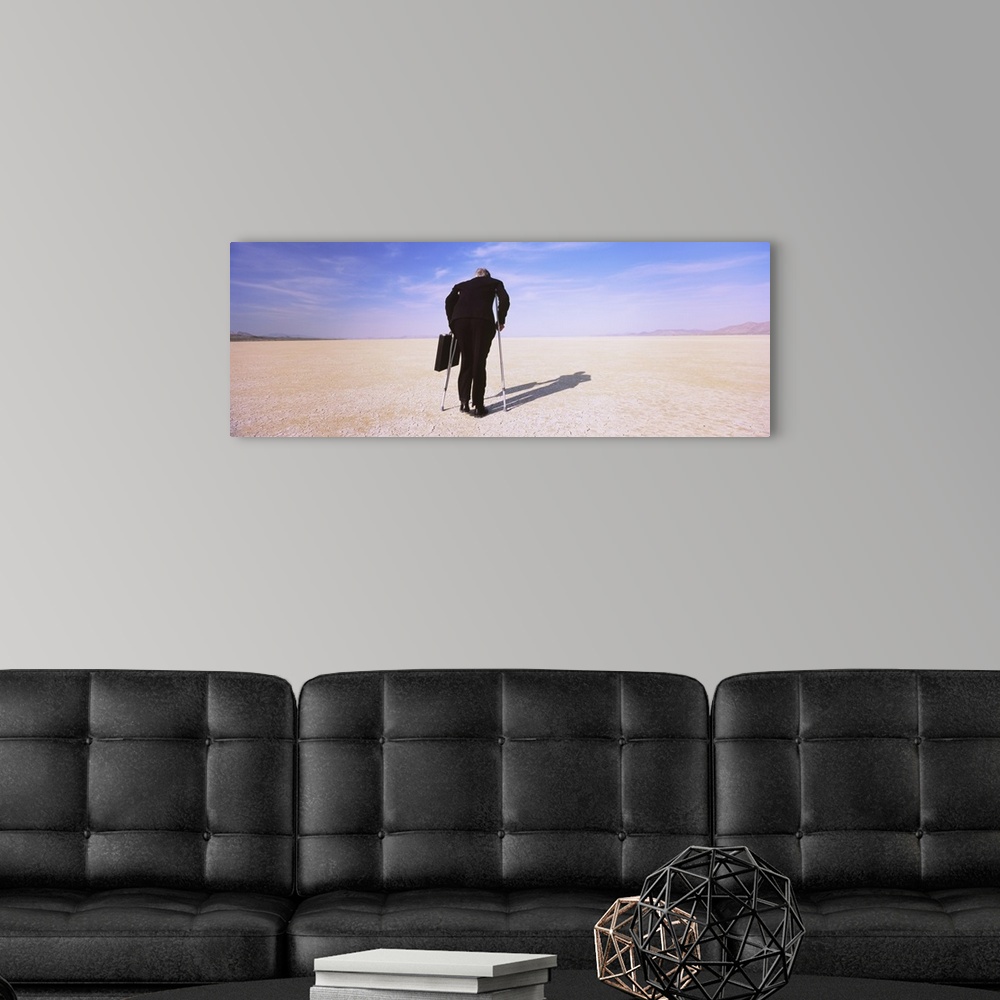 A modern room featuring Businessman walking in a desert on crutches with a briefcase, Black Rock Desert, Nevada