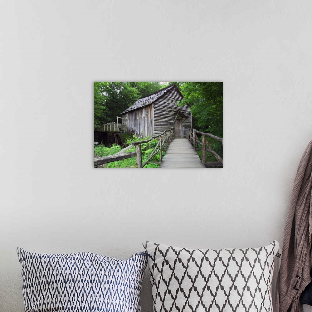 A bohemian room featuring Picture taken of an old mill that has a small bridge path leading up to and is surrounded by lush...