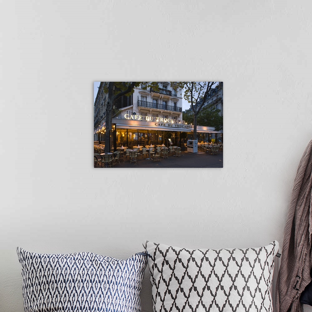 A bohemian room featuring A photograph at dusk of the Cafe Du Trocadero in Paris, France.