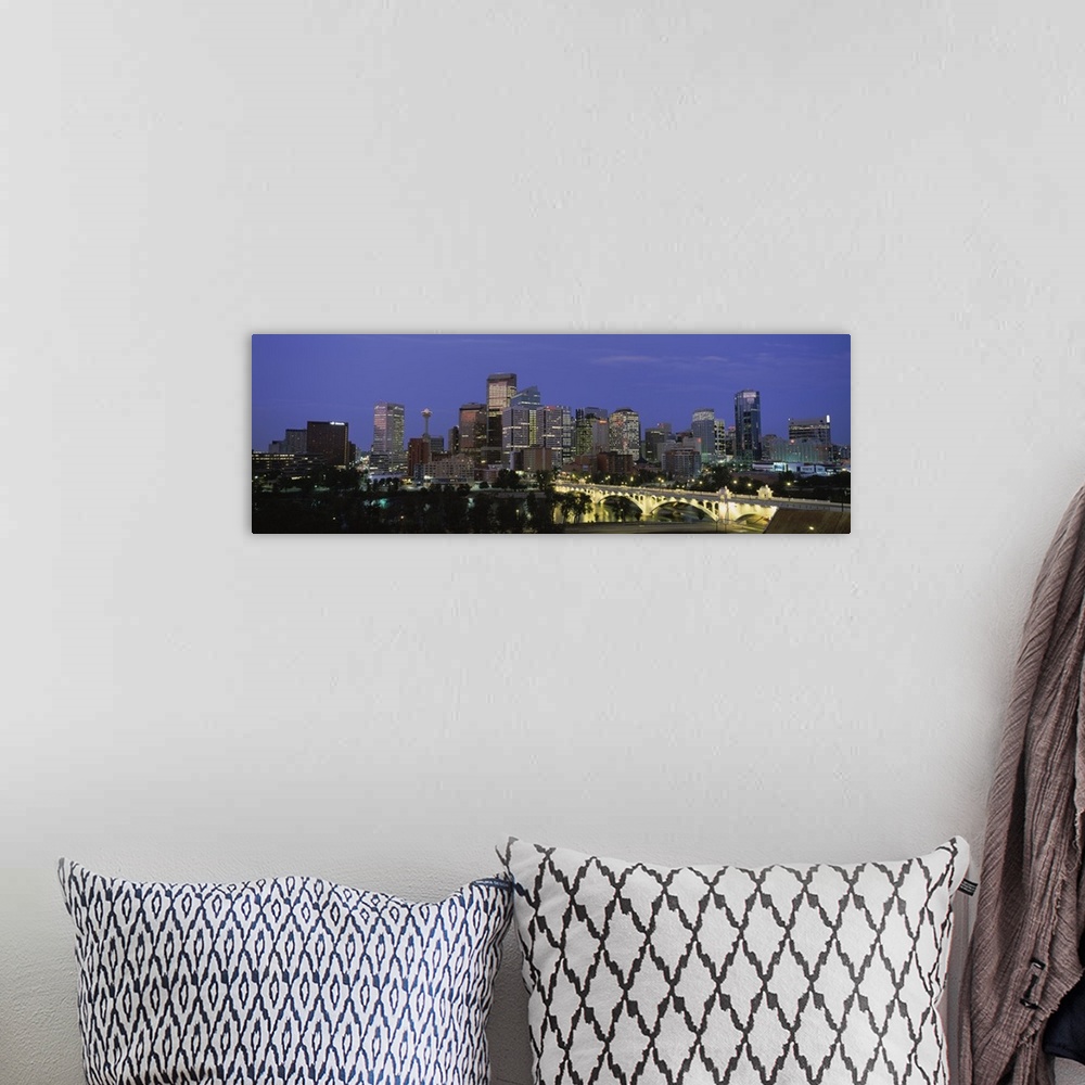 A bohemian room featuring Panoramic image of downtown Calgary lit up at dusk.