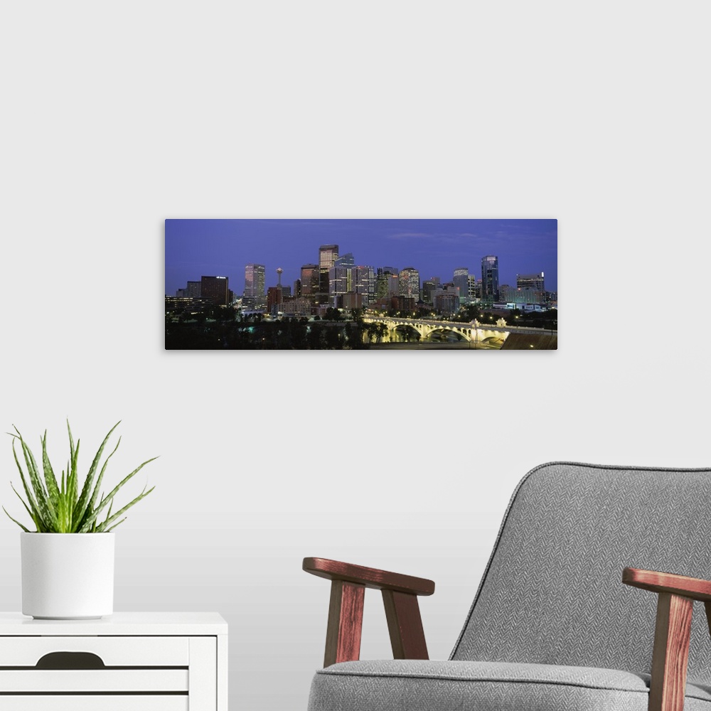 A modern room featuring Panoramic image of downtown Calgary lit up at dusk.