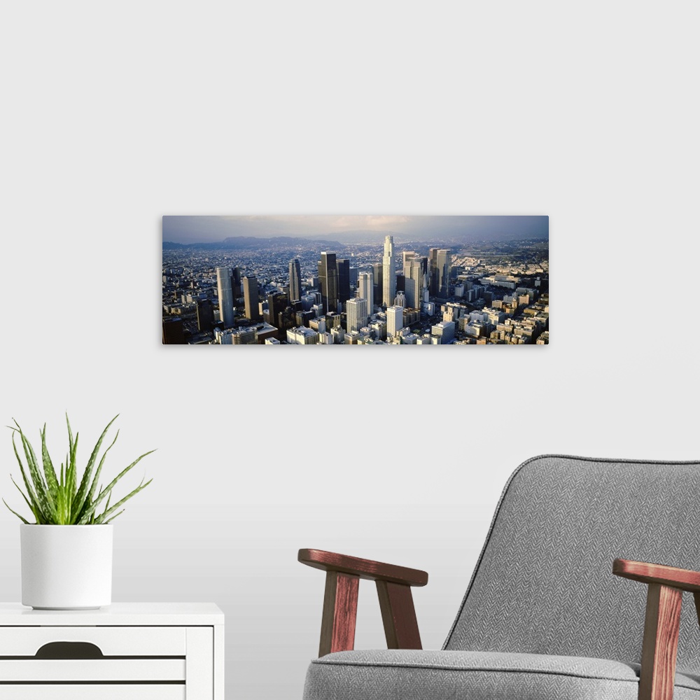 A modern room featuring Wide angle, aerial photograph on a big canvas of the city of Los Angeles beneath a slightly hazy ...