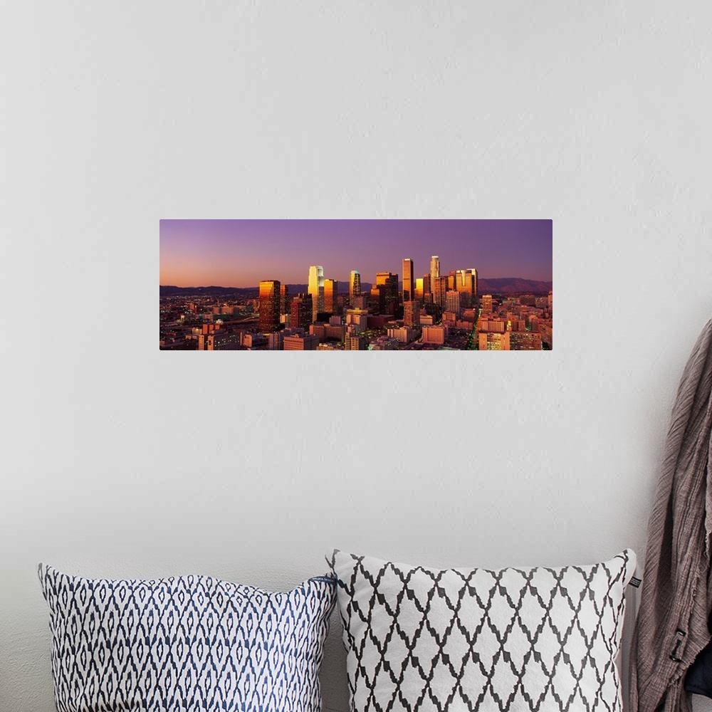 A bohemian room featuring Panoramic photograph of west coast city skyline at dusk.  The buildings and skyscrapers are lit u...