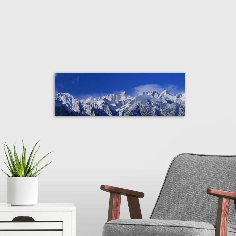 A modern room featuring Panoramic photograph of snow covered Mount Whitney beneath a vibrant blue sky in California.