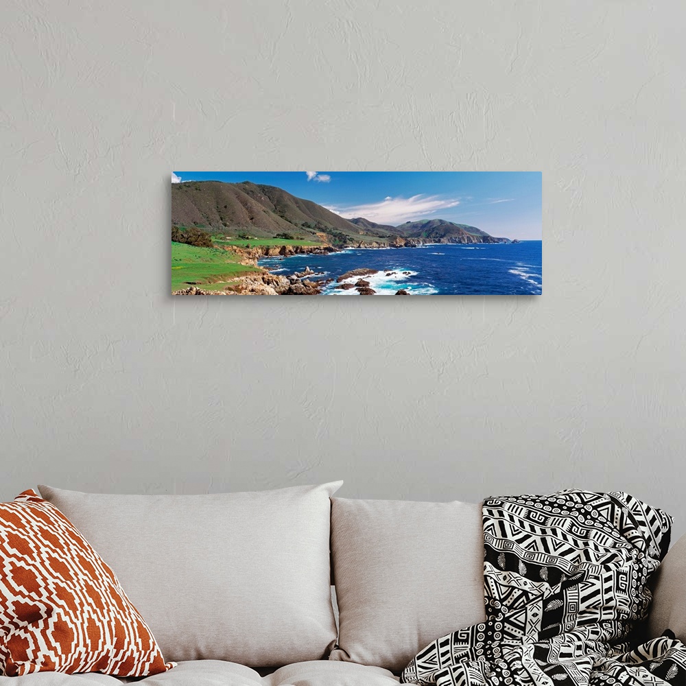 A bohemian room featuring Wide angle photograph of the coastline in Big Sure, California.  Hills jutting into the blue wate...