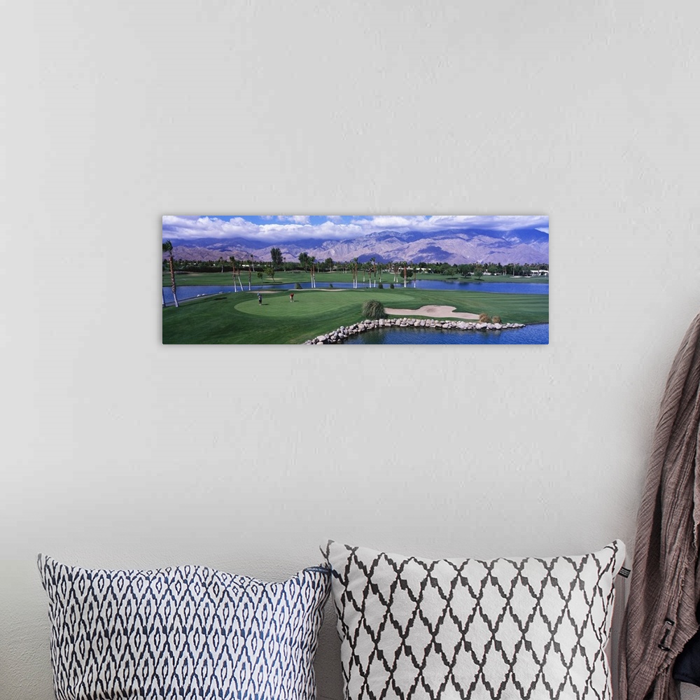 A bohemian room featuring This panoramic photograph shows the immaculate oasis with mountains and clouds in the distance.