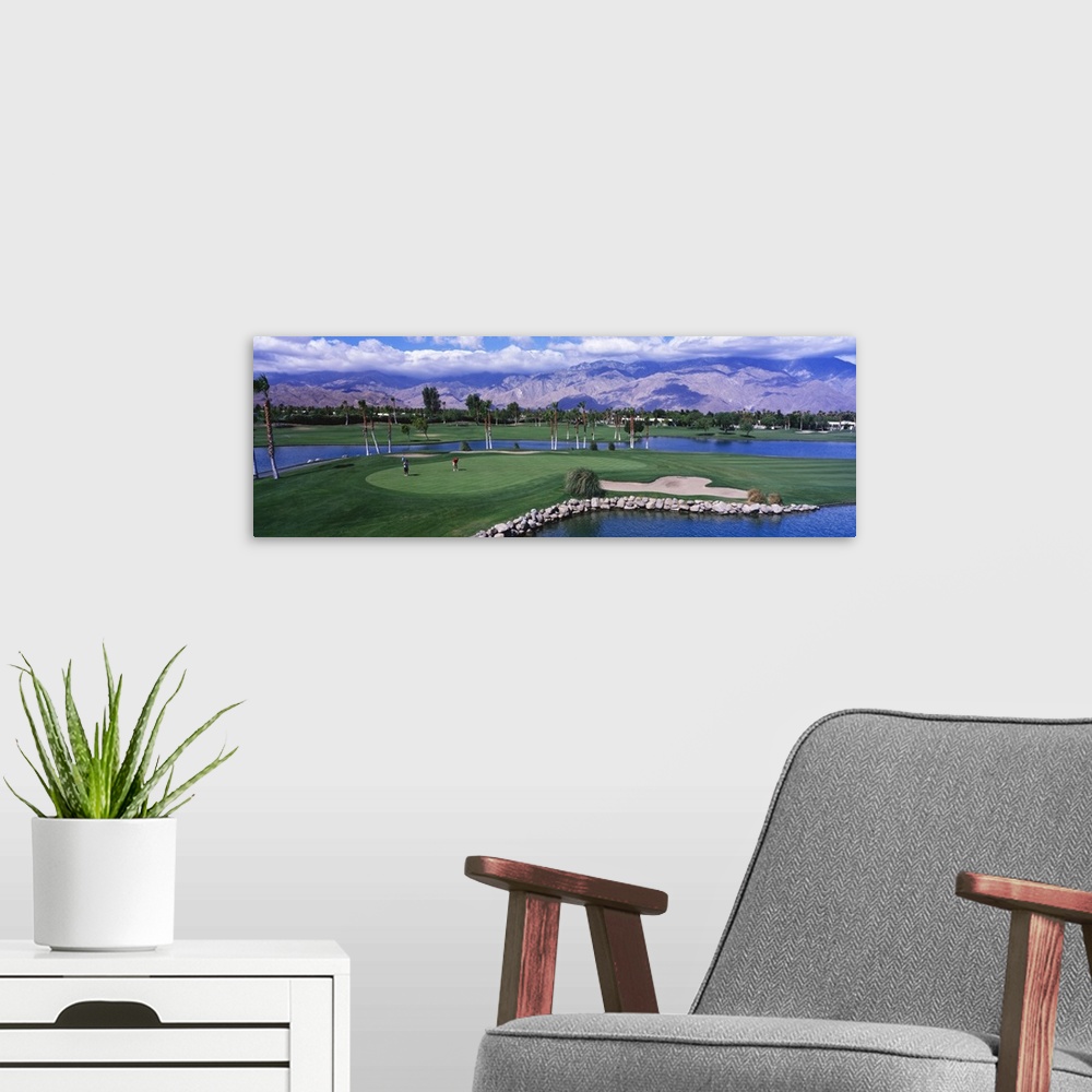 A modern room featuring This panoramic photograph shows the immaculate oasis with mountains and clouds in the distance.