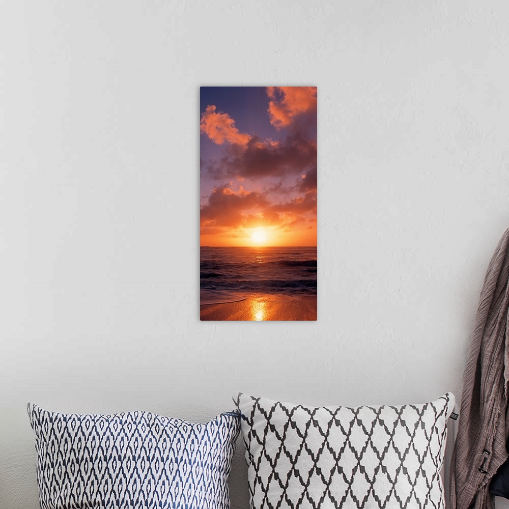 A bohemian room featuring This vertical photograph shows the sun setting at the beach as waves wash against the shore.